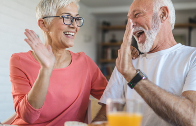 Older couple high fiving over business GiC rates