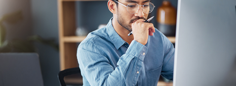 Man reading potential scam email on laptop