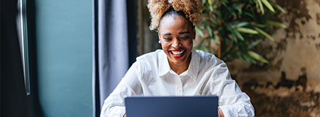 Woman reading about Market-Linked GICs on laptop