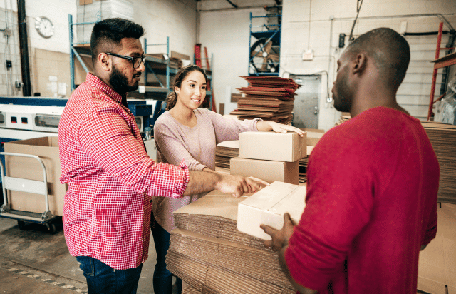 Business owner meeting with clients on warehouse floor