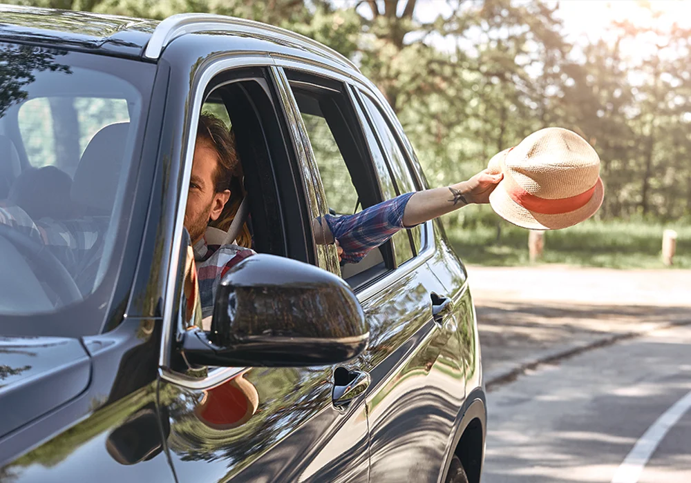 A hand holding a debit card above a payment terminal for a contactless transaction