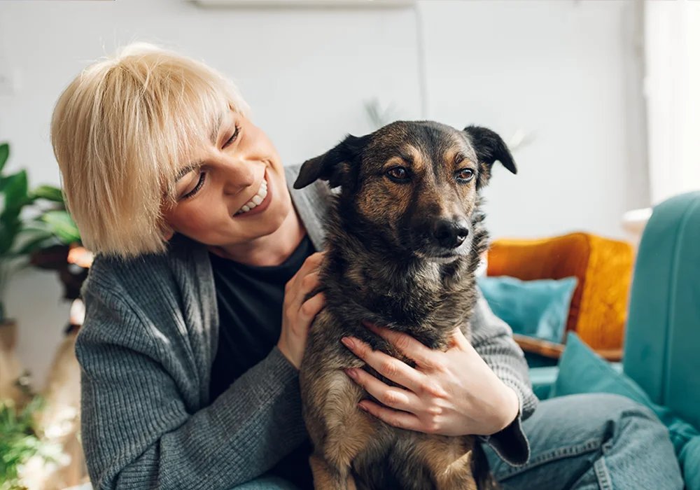 Older man sits on a sofa talking on the phone and using a laptop