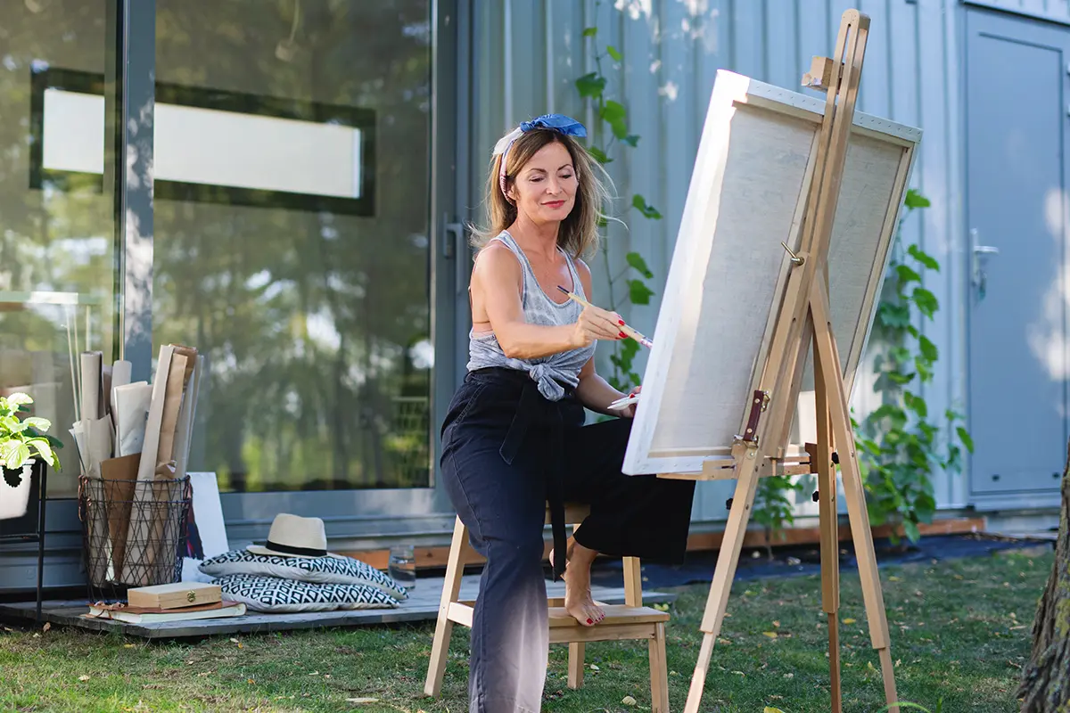Artist painting outdoors on easel.