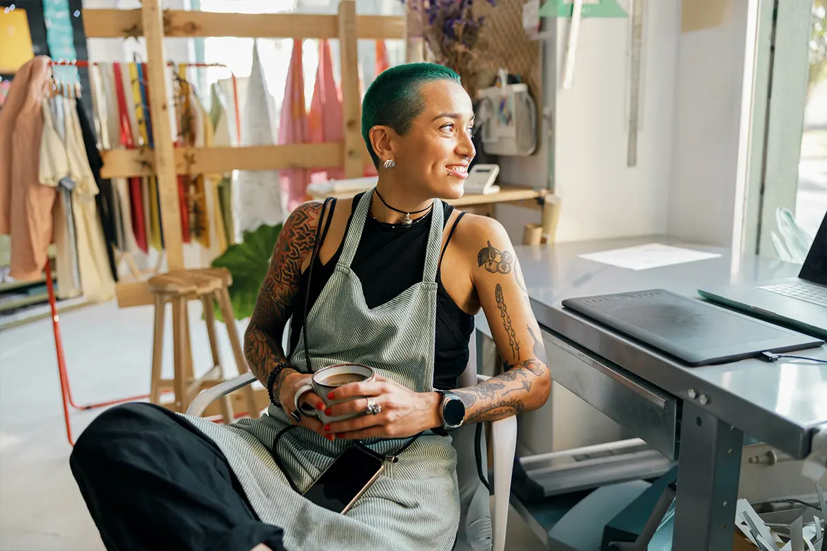 Student smiling in hallway holding backpack straps