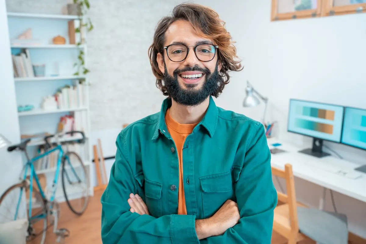 Smiling creative entrepreneur in a home workspace, representing financial stability and peace of mind built through smart emergency fund planning.