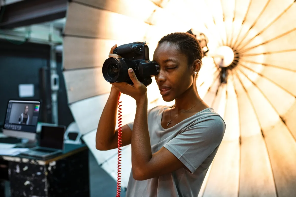 Independent photographer holding a camera in a studio, reflecting borrowing for freelancers supported by Creative Arts Financial financing options. 