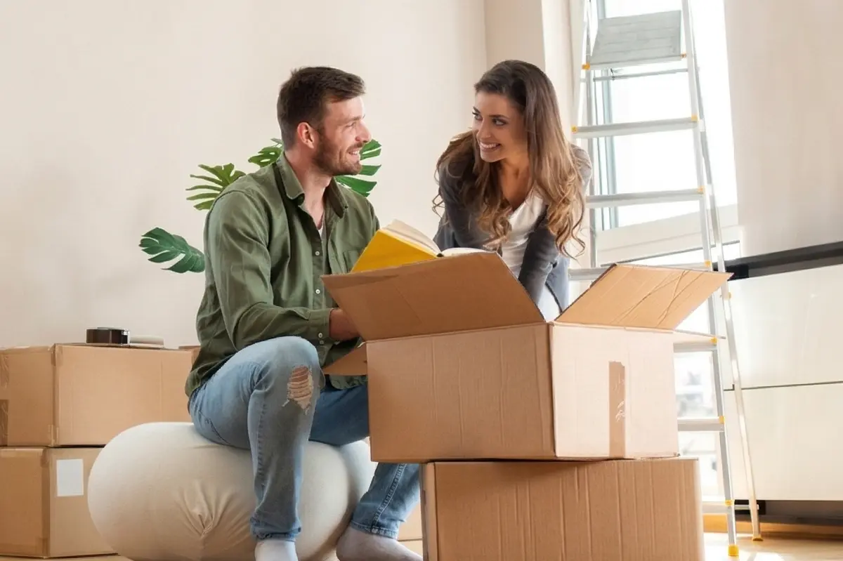 A couple unpacking moving boxes in their new home.